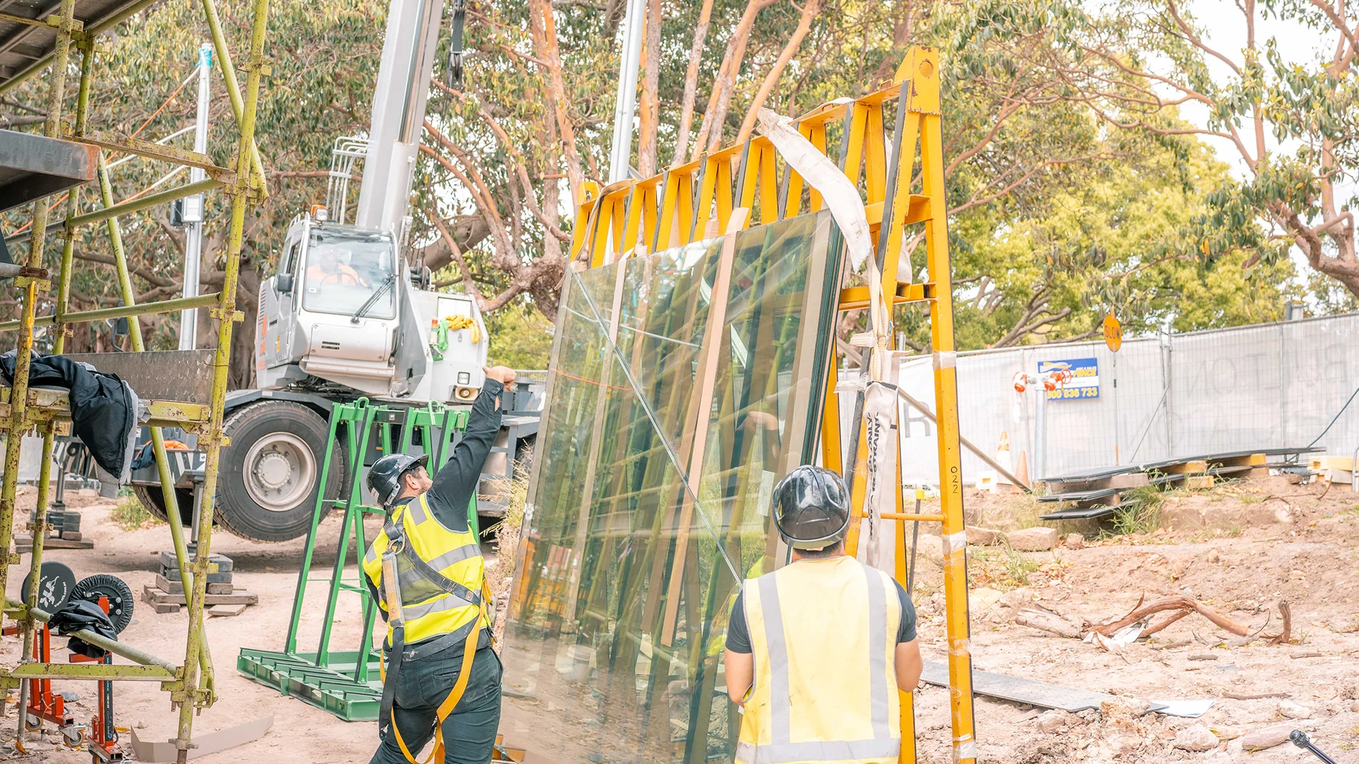 Male workers ensuring glass is secure on glass lifting crane