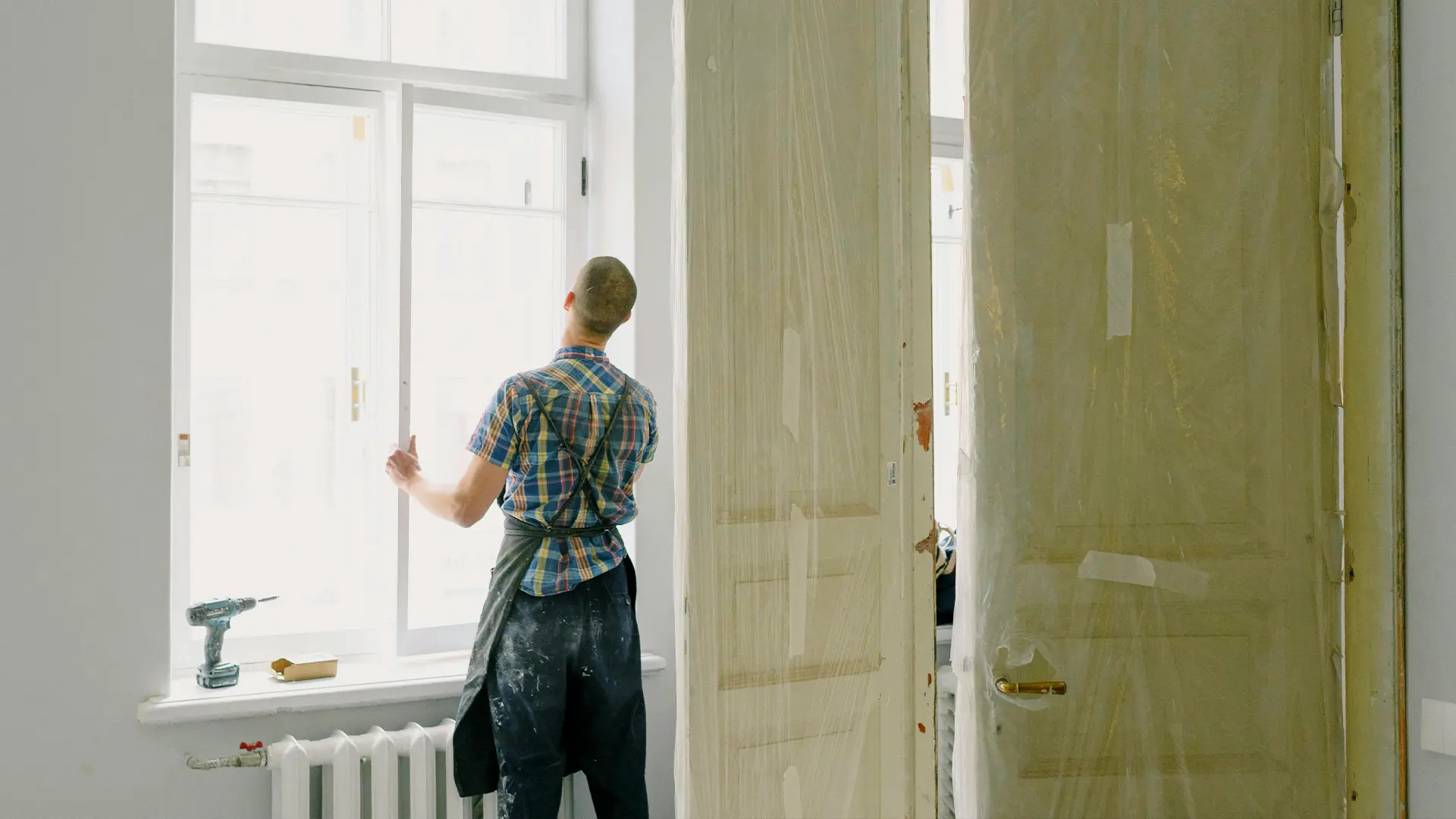 Glazier installing a glass window in a home